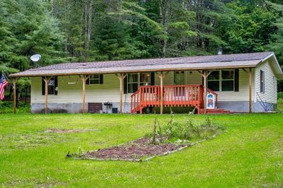 Ranch-style home featuring central AC unit and a front yard | Image 1