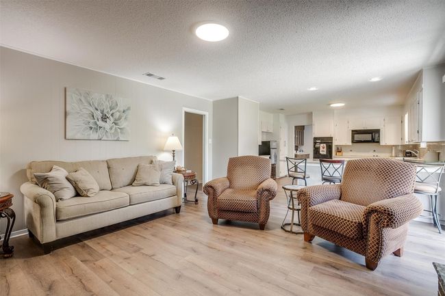 Living room featuring light wood-style flooring and a textured ceiling | Image 14