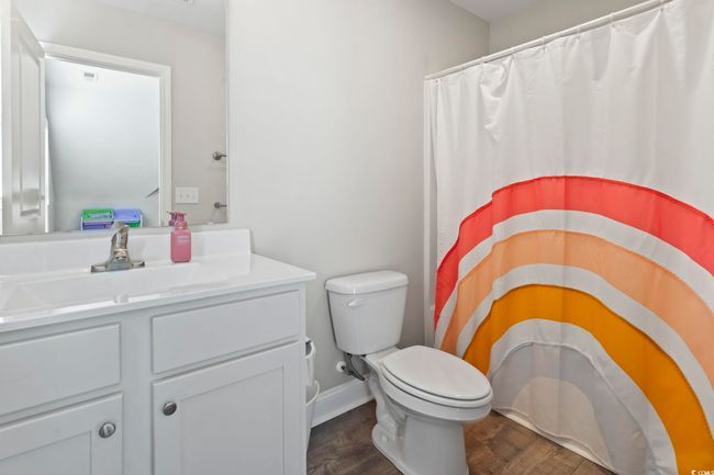 Full bathroom with vanity, a shower with curtain, toilet, and wood finished floors | Image 28