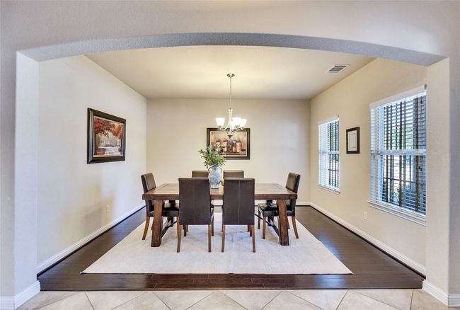Hardwood-type floor in formal dining space featuring a chandelier and multiple windows | Image 7