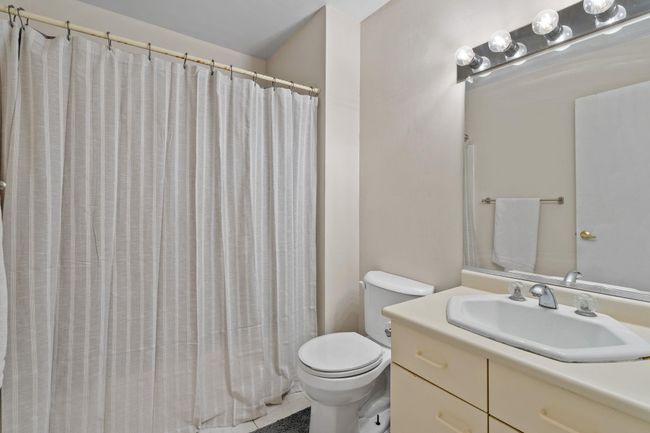 Bathroom featuring toilet, a shower with curtain, and vanity | Image 13