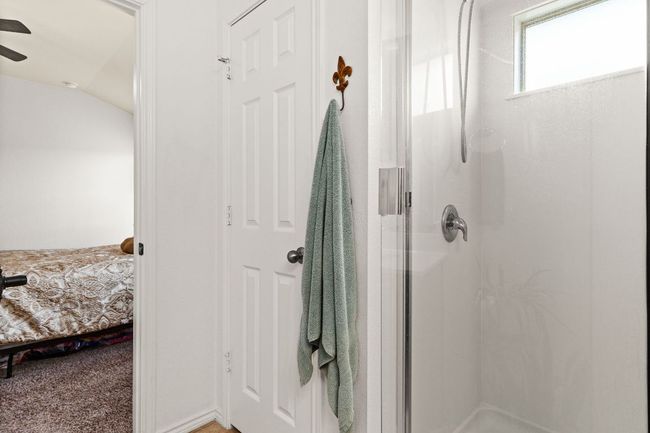 Ensuite bathroom featuring a shower stall, ensuite bathroom, ceiling fan, and lofted ceiling | Image 17