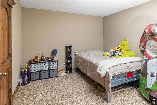Carpeted bedroom with a textured ceiling | Image 22