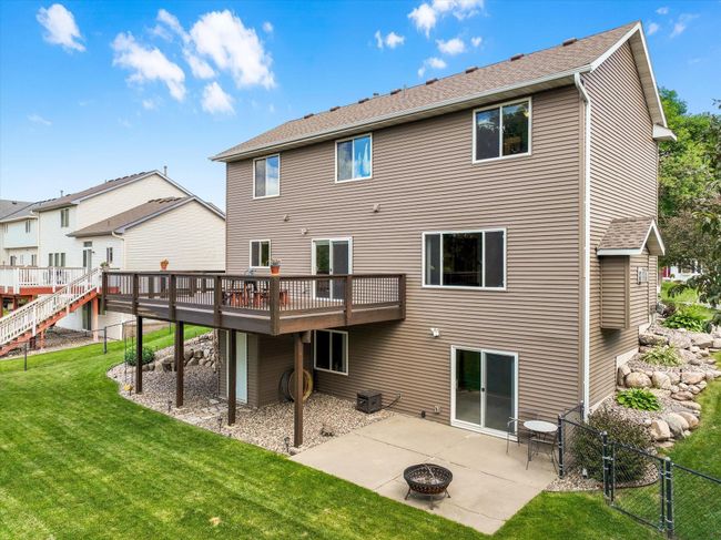The fenced in back yard features a deck, patio, and 2 storage sheds | Image 4