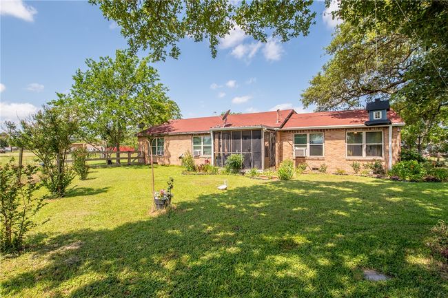 Rear view of house with a sunroom, a yard, and brick siding | Image 10
