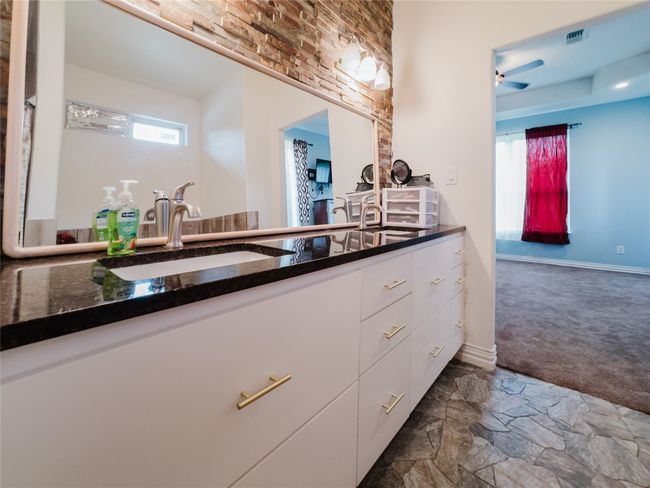 Bathroom featuring plenty of natural light, vanity, stone finish floors, and a ceiling fan | Image 21