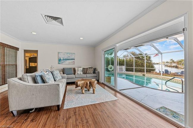 Living area with wood finished floors, visible vents, and ornamental molding | Image 19
