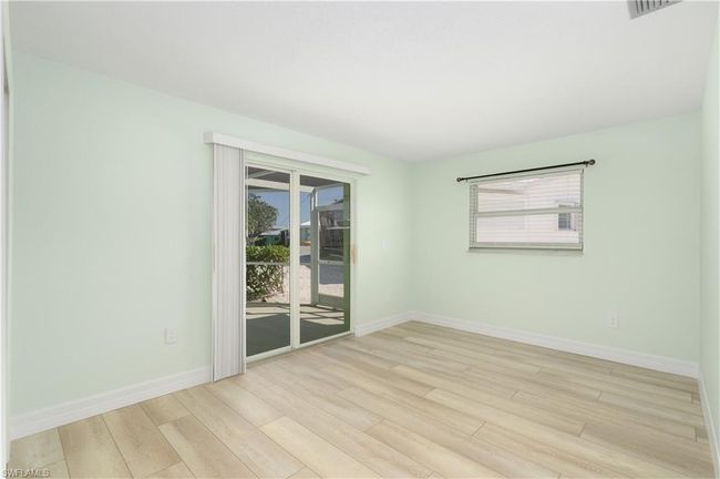 Bedroom featuring vinyl wood finished floors, pool access and a healthy amount of sunlight | Image 10