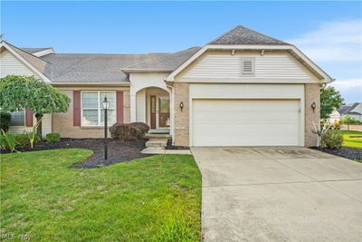 Ranch-style home with a garage and a front yard | Image 1