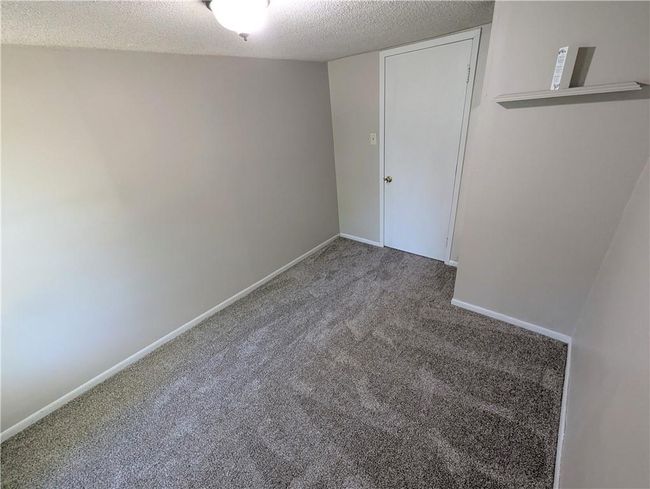 Spare room featuring carpet, a textured ceiling, and baseboards | Image 15