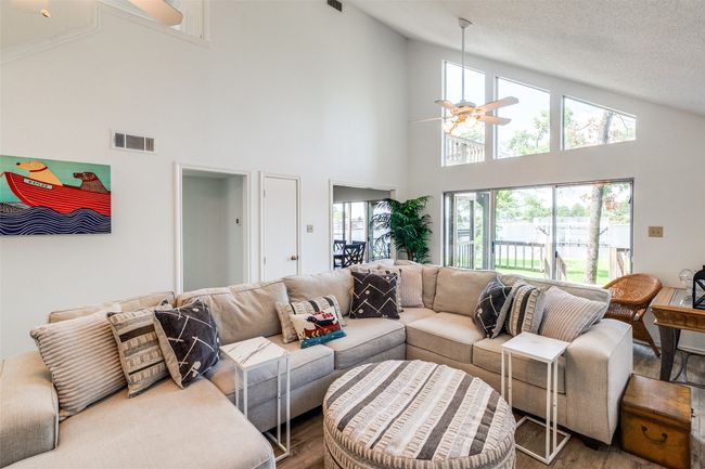 Living room with a ceiling fan, wood finished floors, high vaulted ceiling | Image 5