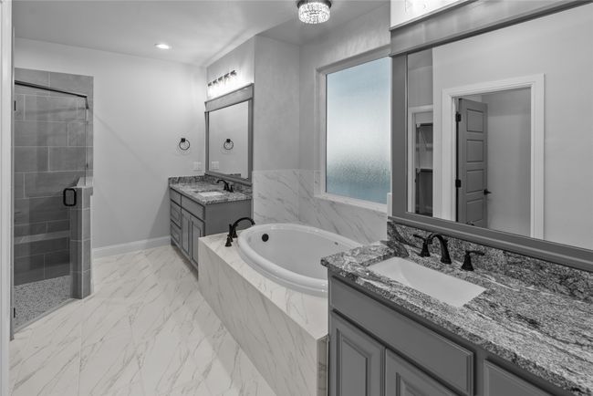 Full bath featuring a stall shower, two vanities, a bath, marble look tile flooring, and recessed lighting | Image 19