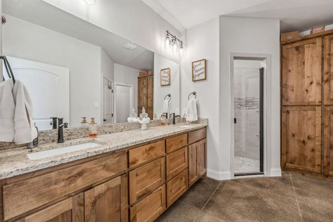 Bathroom featuring double vanity, a shower stall, and baseboards | Image 14