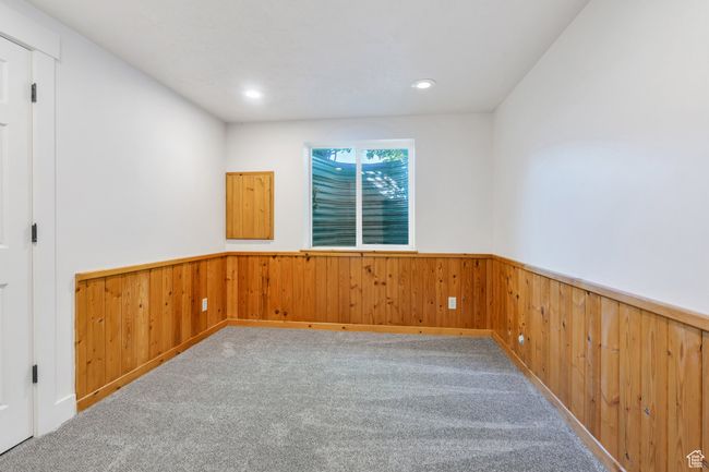 Carpeted spare room featuring a wainscoted wall, wooden walls, and recessed lighting | Image 20