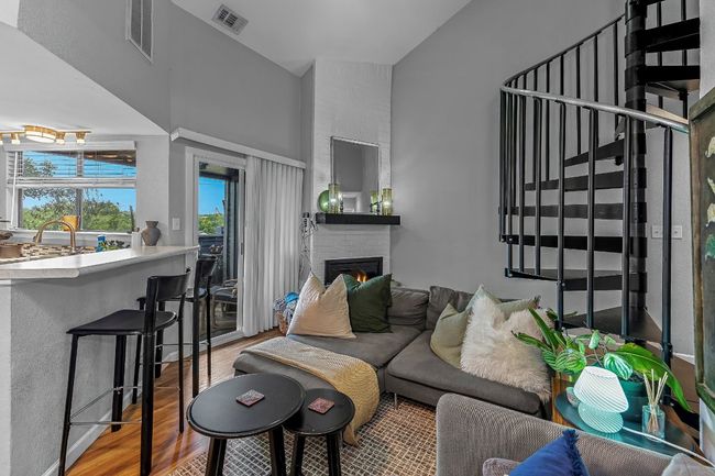 Living room with wood finished floors, a brick fireplace, and a towering ceiling | Image 4