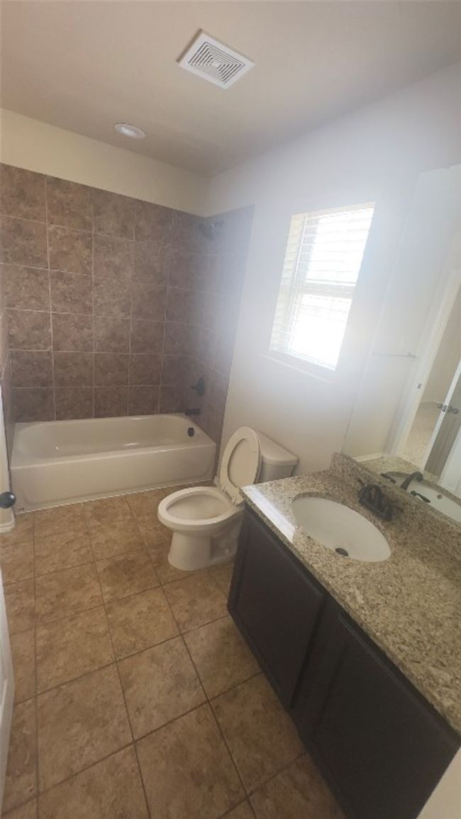 Bathroom featuring vanity, washtub / shower combination, and tile patterned floors | Image 11