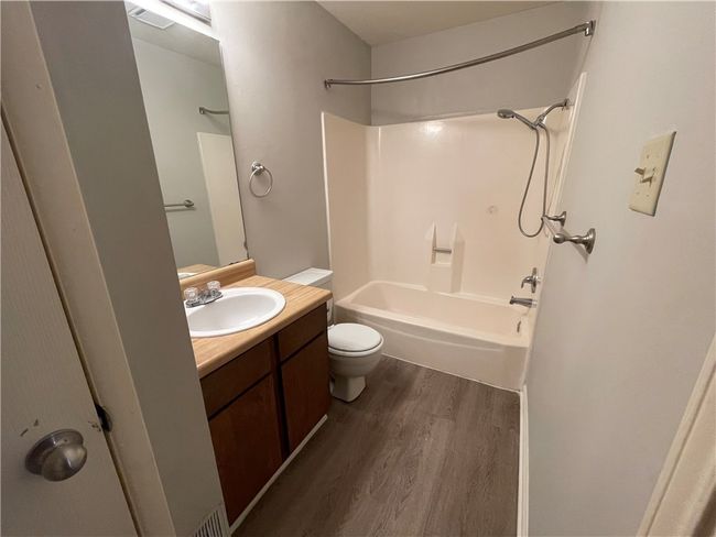 Full bathroom with shower / bath combination, vanity, toilet, and wood-type flooring | Image 10
