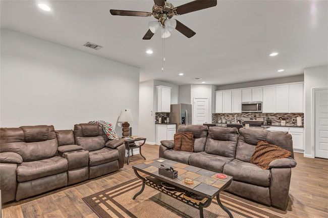Living area has a ceiling fan and recessed lighting | Image 23