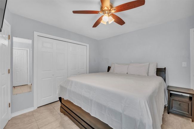 Bedroom featuring light tile patterned floors, baseboards, ceiling fan, and a closet | Image 19