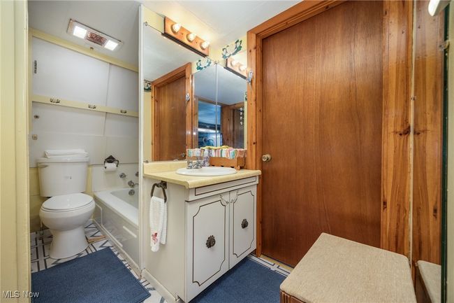 Full bathroom featuring toilet, a washtub, and vanity | Image 22