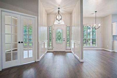 Foyer featuring dark wood-type flooring, french doors, a chandelier, and plenty of natural light | Image 3