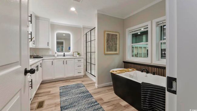 Bathroom featuring a shower stall, vanity, a freestanding tub, wood finished floors, and recessed lighting | Image 24
