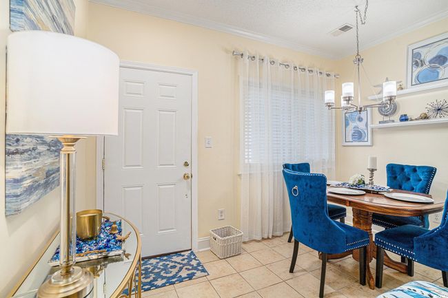 Dining area with a chandelier, light tile patterned floors, and crown molding | Image 7