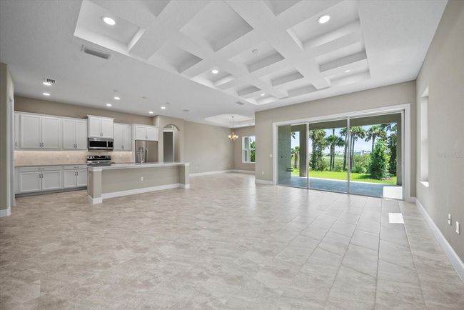 Great room with living, kitchen and dining showcases your peaceful pool area and intracoastal waterway view | Image 12