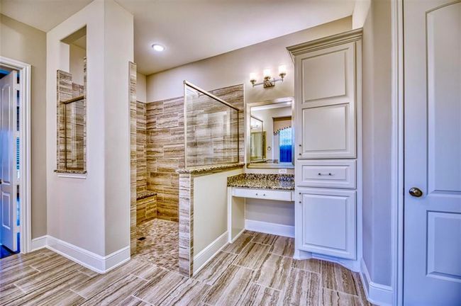 This bathroom features a spacious walk-in shower with elegant tile work, a granite countertop vanity with ample storage, and modern lighting fixtures. The design is sleek and sophisticated, perfect for a contemporary home. | Image 31