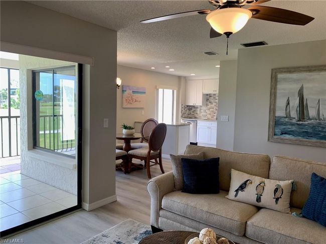 Living room with ceiling fan, light wood-type flooring, and a textured ceiling | Image 7