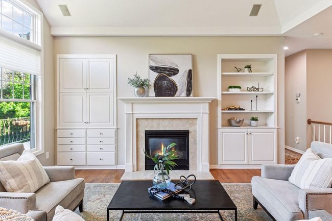 Bright and airy living room with vaulted ceilings, large windows, and a cozy gas fireplace as the focal point. | Image 4