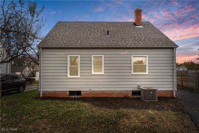 Back house at dusk with a lawn and central AC | Image 3