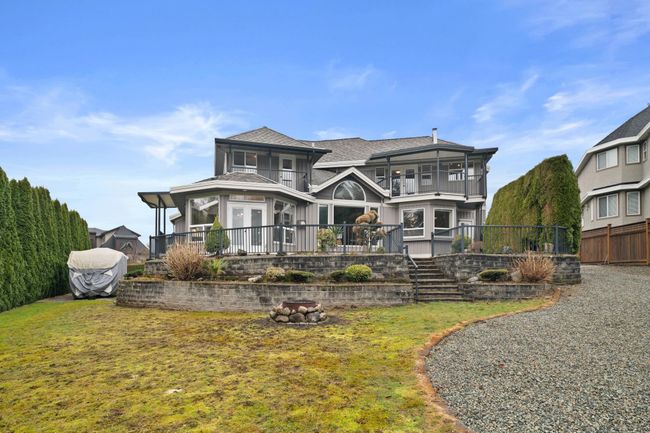 Rear view of house with a yard, a balcony, and fence | Image 37