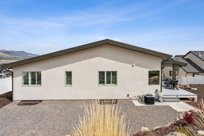 Back of property with cooling unit, a patio, stucco siding, and fence | Image 63