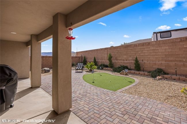 View of patio / terrace featuring an area to practice putting, a fenced backyard, and grilling area | Image 47