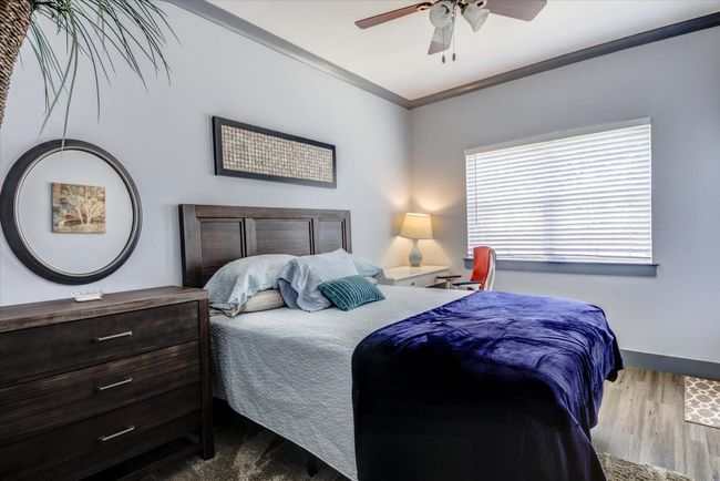 Bedroom featuring wood finished floors, crown molding, and ceiling fan | Image 14