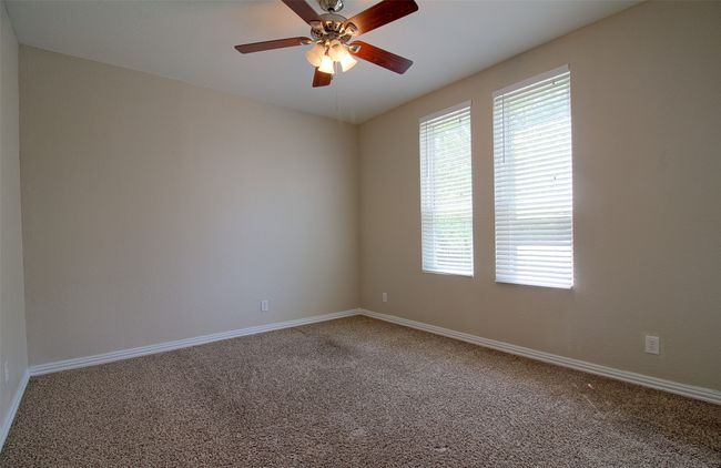 Carpeted spare room featuring baseboards and a ceiling fan | Image 12