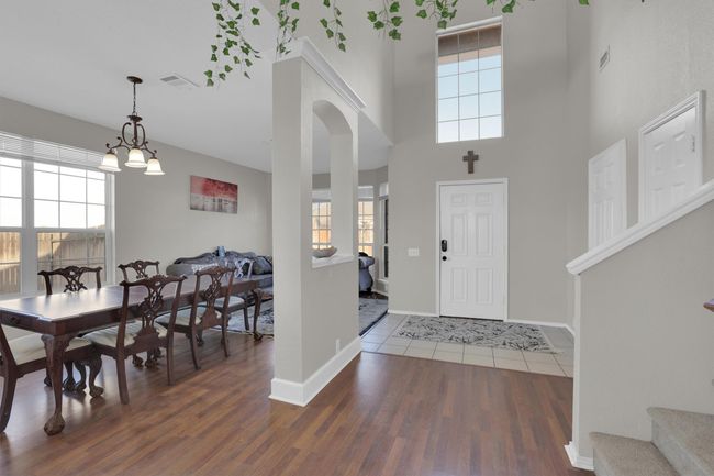 Entryway with a high ceiling, dark wood-style flooring, visible vents, and baseboards | Image 20