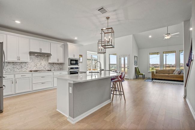 Kitchen featuring stainless steel appliances, plenty of natural light, tasteful backsplash, under cabinet range hood, and recessed lighting | Image 5