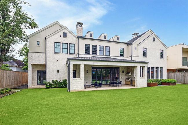 The covered patio, outdoor dining area, and built-in grill are perfect to enjoy year round. | Image 9
