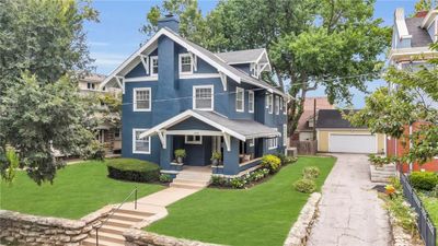 View of front of house featuring a porch, a garage, a front lawn, and cooling unit | Image 1