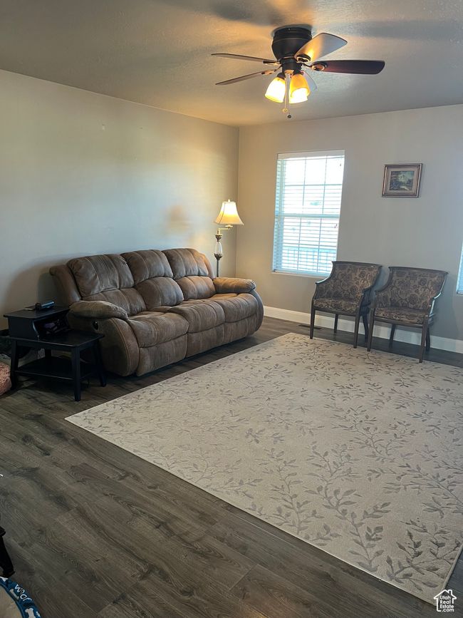 Living room with ceiling fan and dark wood-style floors | Image 36