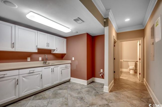 Kitchen with a sink, ornamental molding, baseboards, white cabinetry, and light countertops | Image 15