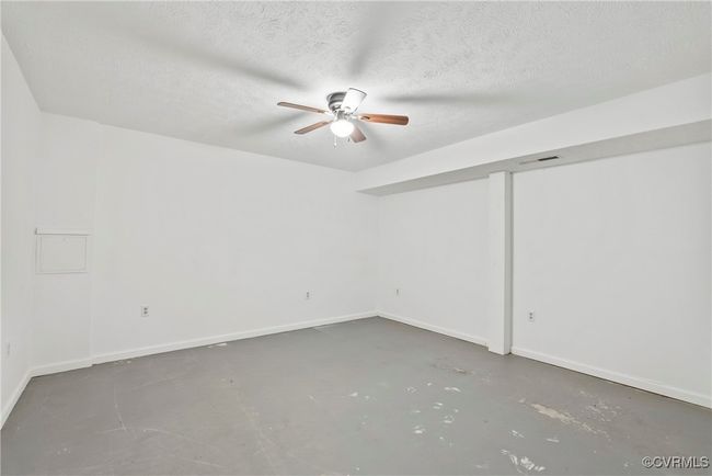 Empty room featuring concrete flooring, a textured ceiling, visible vents, and ceiling fan | Image 25