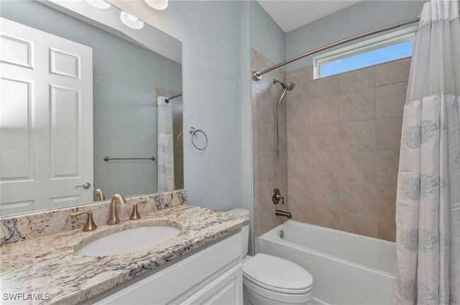 Bathroom featuring shower / bath combo, toilet, and vanity | Image 13