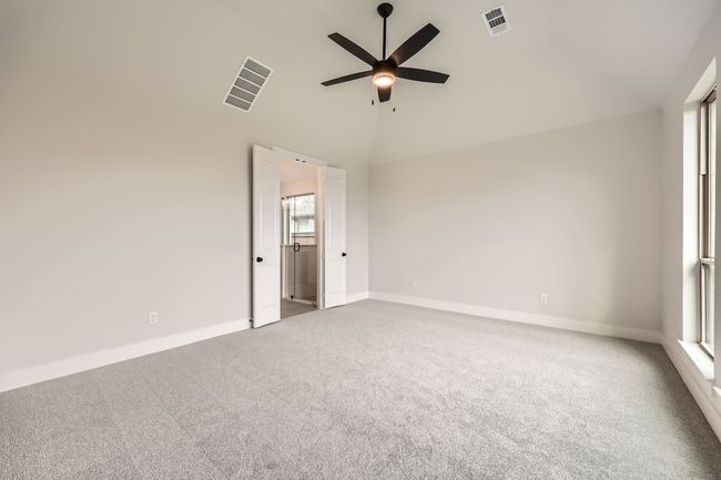 Empty room featuring a ceiling fan, carpet floors, high vaulted ceiling, and visible vents | Image 13