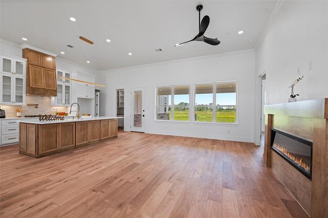 Spacious and inviting living room with elegant LVP floors, a sleek modern fireplace, and large windows offering stunning views and natural light. Perfect for relaxation and entertaining. | Image 19