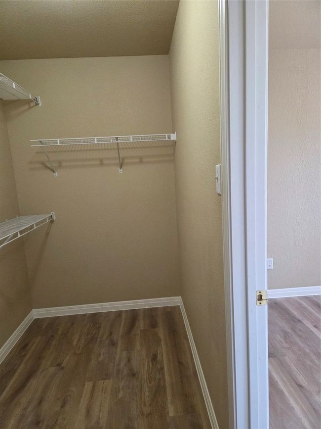 Walk in closet featuring wood finished floors | Image 33