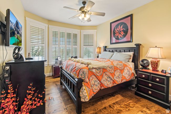 Bedroom featuring ceiling fan, dark hardwood / wood-style flooring, and multiple windows | Image 55