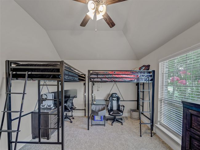 Carpeted bedroom featuring lofted ceiling, an office area, and ceiling fan | Image 29